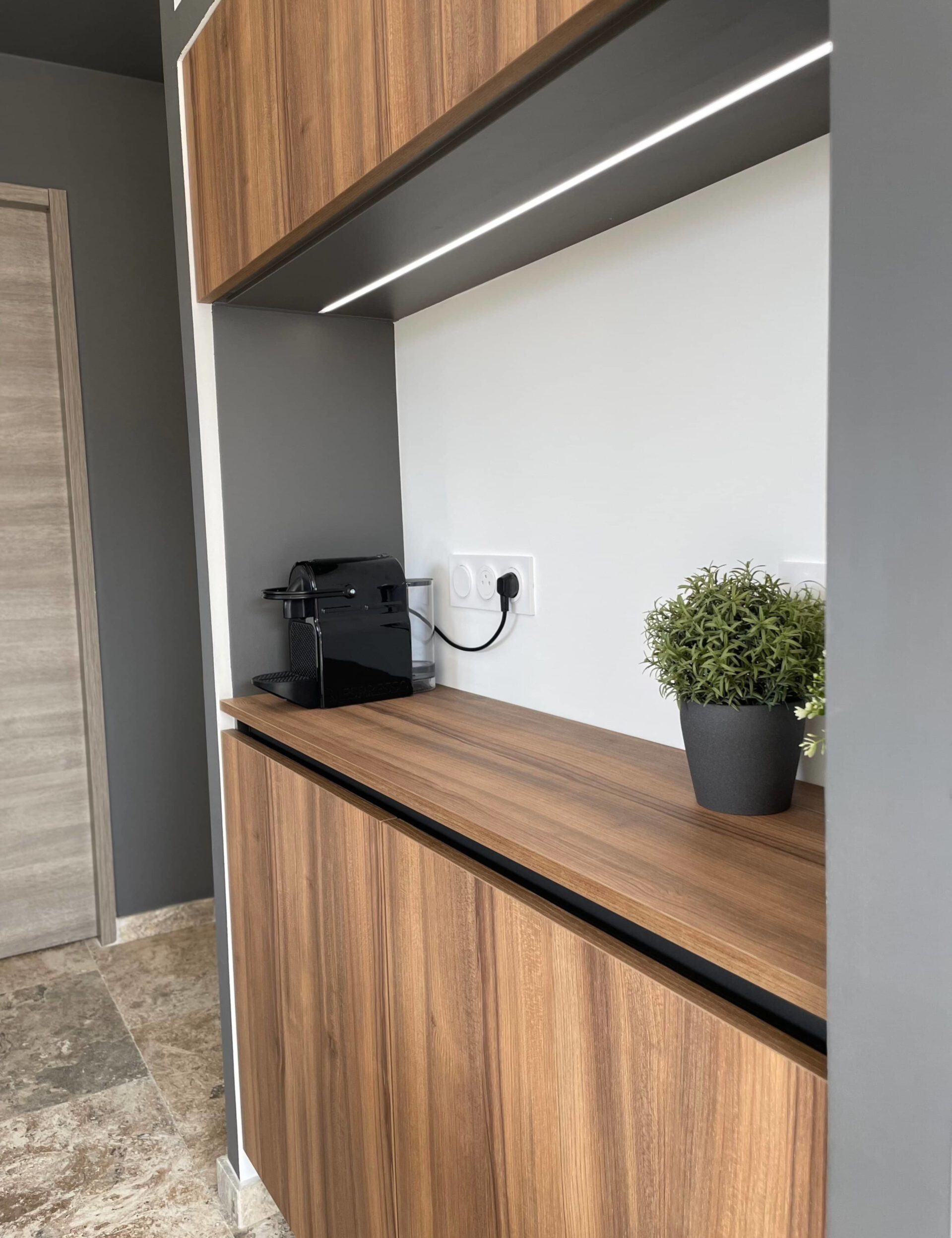 Rangement optimisé dans une cuisine moderne à Laudun-l’Ardoise, avec niche intégrée pour les appareils électroménagers.